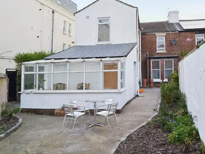 a patio with a table and chairs in front of a house at Sandfield The Promenade in Southport