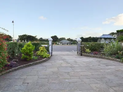 a stone walkway with a gate in a garden at Sandfield The Promenade in Southport