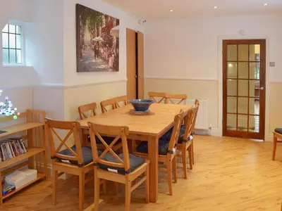 a dining room with a wooden table and chairs at Sandfield The Promenade in Southport
