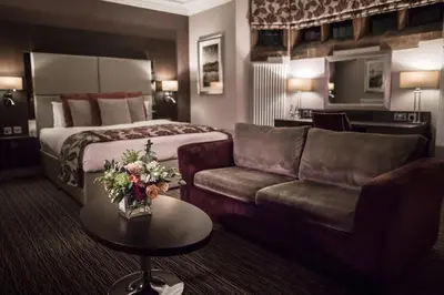 a hotel room with a bed and a couch at Abbey House Hotel in Barrow in Furness
