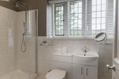 a bathroom with a sink and a shower and a toilet at Abbey House Hotel in Barrow in Furness