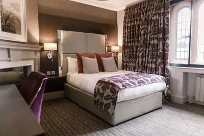 a hotel room with a bed and a fireplace at Abbey House Hotel in Barrow in Furness