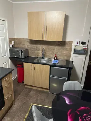a small kitchen with a sink and a microwave at Blackpool Beach Holiday Flats in Blackpool