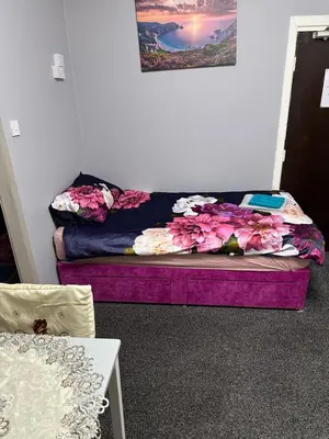 a bed with flowers on it in a room at Blackpool Beach Holiday Flats in Blackpool