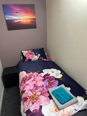 a bedroom with two beds with flowers on it at Blackpool Beach Holiday Flats in Blackpool