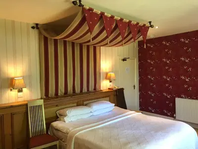 a bedroom with a bed with a canopy over it at Calf's Head Hotel in Clitheroe
