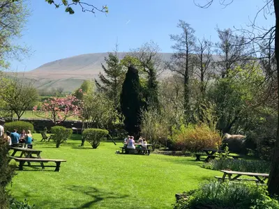 a group of people sitting on benches in a park at Calf's Head Hotel in Clitheroe