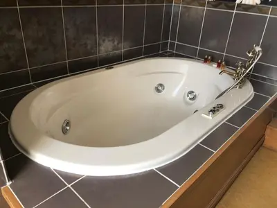 a white bath tub in a tiled bathroom at Calf's Head Hotel in Clitheroe