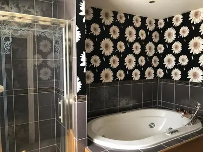 a bathroom with a tub and a black and white wallpaper at Calf's Head Hotel in Clitheroe
