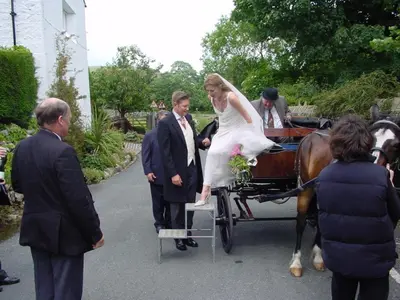a bride and groom being pulled in a horse drawn carriage at Calf's Head Hotel in Clitheroe