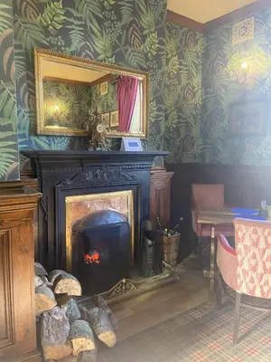 a living room with a fireplace and a mirror at Calf's Head Hotel in Clitheroe