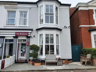 a building with a bench in front of a store at The Braemar Southport in Southport