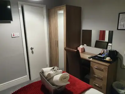 a hotel room with a desk and a mirror at The Braemar Southport in Southport