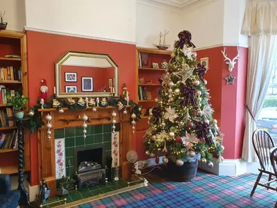 a living room with a christmas tree and a fireplace at The Braemar Southport in Southport