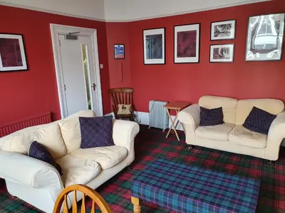 a living room with red walls and white couches at The Braemar Southport in Southport