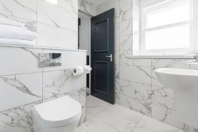 a white bathroom with a toilet and a sink at The Sir Thomas Hotel in Liverpool