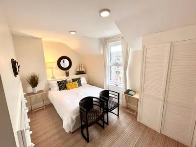 a bedroom with a bed and a table and chairs at Holland House in New Brighton