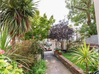 a garden with plants and trees and a fence at Holland House in New Brighton