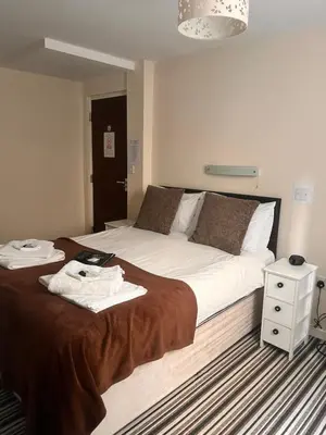 a bedroom with a large bed and a night stand at The Oxfordshire in Blackpool