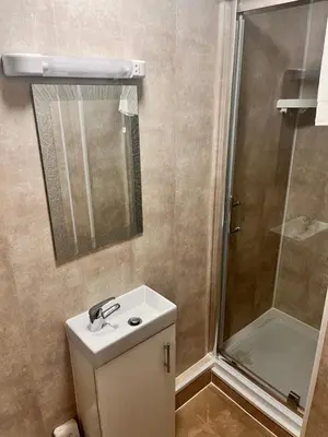 a bathroom with a shower and a toilet and a sink at The Oxfordshire in Blackpool