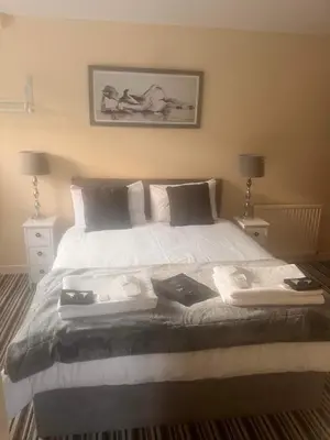 a bedroom with a large white bed with two lamps at The Oxfordshire in Blackpool