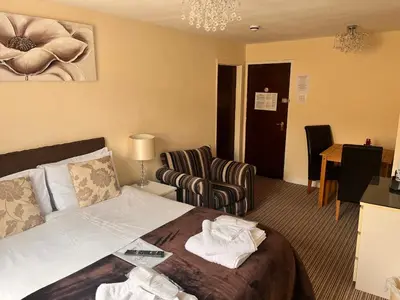 a hotel room with a bed and a chair at The Oxfordshire in Blackpool