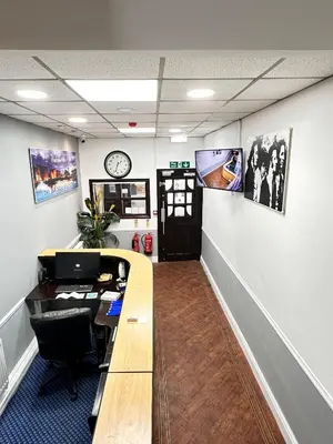 an office with a desk and a clock on the wall at Throstles Nest Hotel in Liverpool