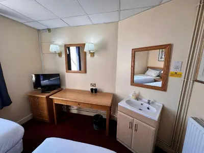 a room with a desk with a sink and a mirror at Throstles Nest Hotel in Liverpool