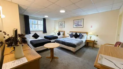 a hotel room with two beds and a couch at Throstles Nest Hotel in Liverpool