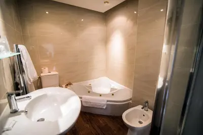 a bathroom with a sink and a toilet at Astley Bank Hotel in Darwen