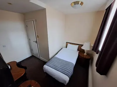 a hotel room with a bed and a lamp at Scarisbrick Hotel in Southport