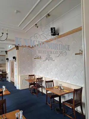 a dining room with tables and chairs and a wall at Scarisbrick Hotel in Southport