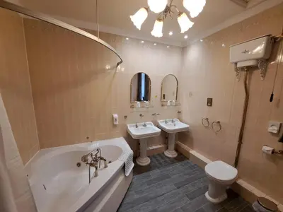 a bathroom with a tub and a toilet and a sink at Scarisbrick Hotel in Southport