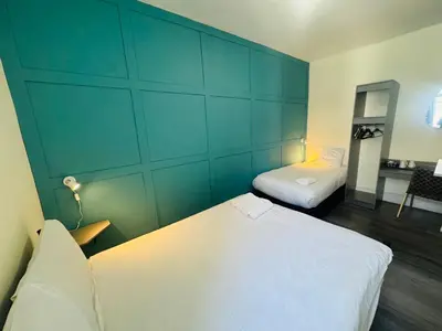 a bedroom with two beds and a blue wall at Calypso hotel Blackpool in Blackpool