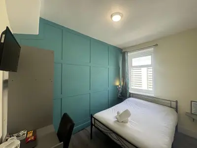 a small room with a bed and a window at Calypso hotel Blackpool in Blackpool