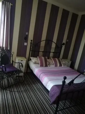 a bedroom with a bed and a chair at Balmoral Lodge Hotel in Southport