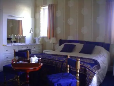 a bedroom with a bed and a table with a night stand at Balmoral Lodge Hotel in Southport
