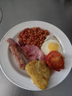 a plate of breakfast food with bacon beans and an egg at Balmoral Lodge Hotel in Southport