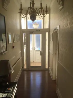 a hallway with a door and a chandelier at The Windsor Carlton in Blackpool