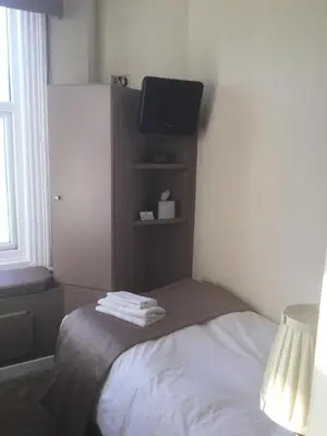 a bedroom with a bed with a tv on it at The Windsor Carlton in Blackpool
