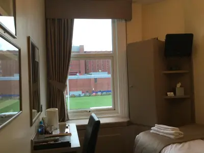 a hotel room with a window with a view of a field at The Windsor Carlton in Blackpool