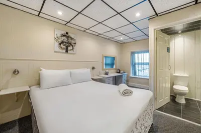 a large white bed in a room with a toilet at Bluewaters Hotel, Blackpool North Promenade in Blackpool