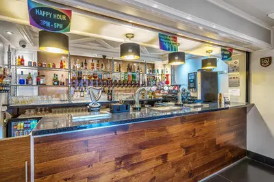 a bar with a wooden counter in a restaurant at Bluewaters Hotel, Blackpool North Promenade in Blackpool