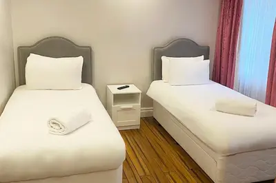 two beds in a small room with white sheets at Bluewaters Hotel, Blackpool North Promenade in Blackpool