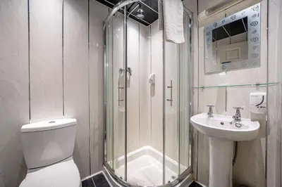a bathroom with a shower and a toilet and a sink at Bluewaters Hotel, Blackpool North Promenade in Blackpool