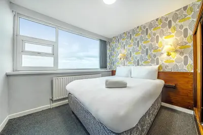 a bedroom with a large bed and a window at Bluewaters Hotel, Blackpool North Promenade in Blackpool