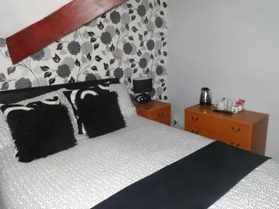 a bedroom with a large bed with black pillows at Windsor Hotel in Blackpool