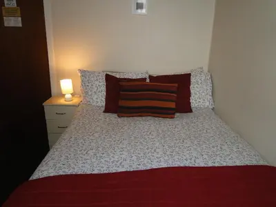 a bedroom with a bed with a red blanket and pillows at Windsor Hotel in Blackpool