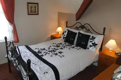 a bedroom with a bed with black and white sheets and pillows at Windsor Hotel in Blackpool