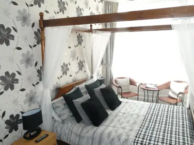 a bedroom with a canopy bed with black pillows at Windsor Hotel in Blackpool